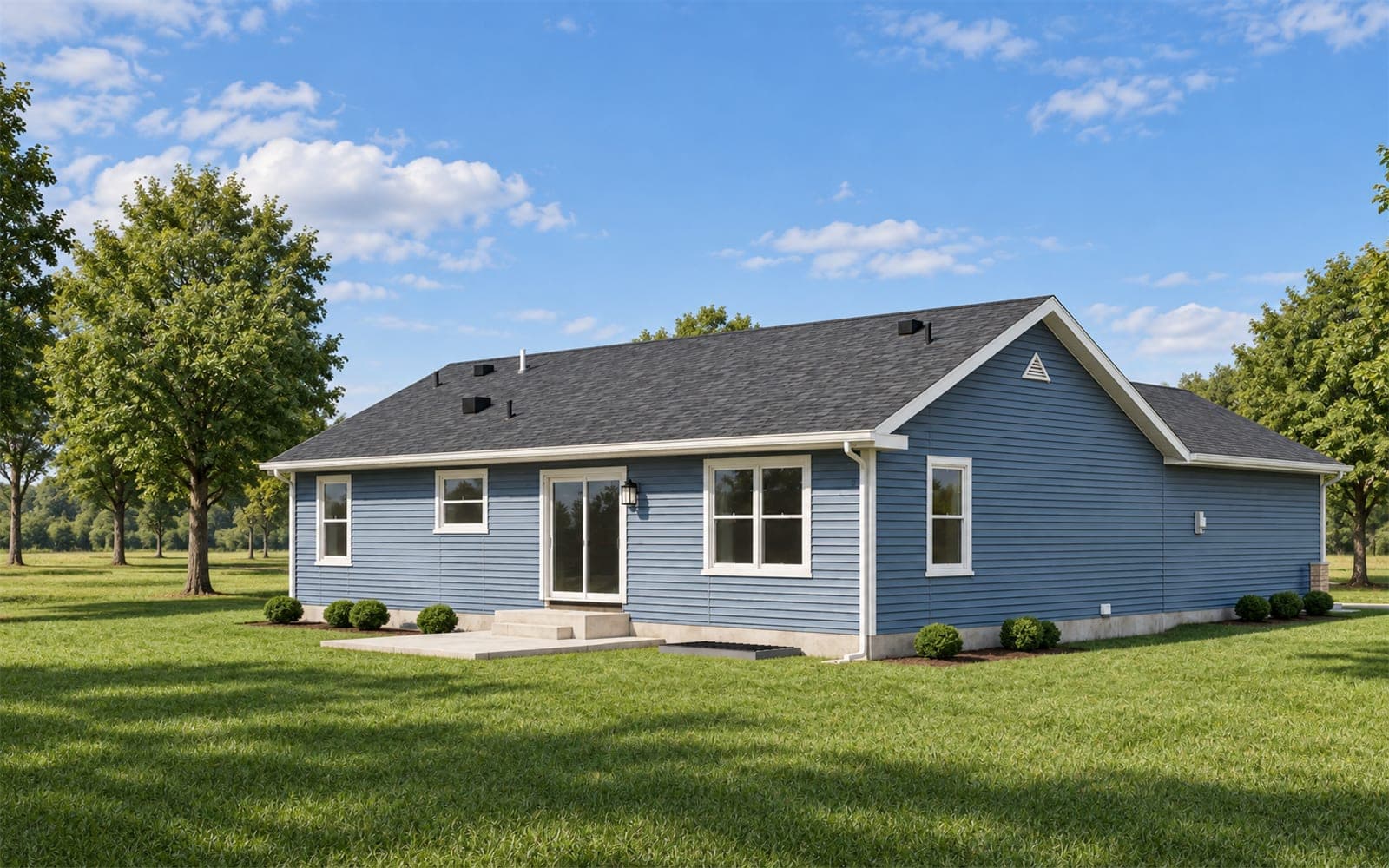 Back of a single-story blue ranch home with a sliding patio door, concrete patio and green lawn