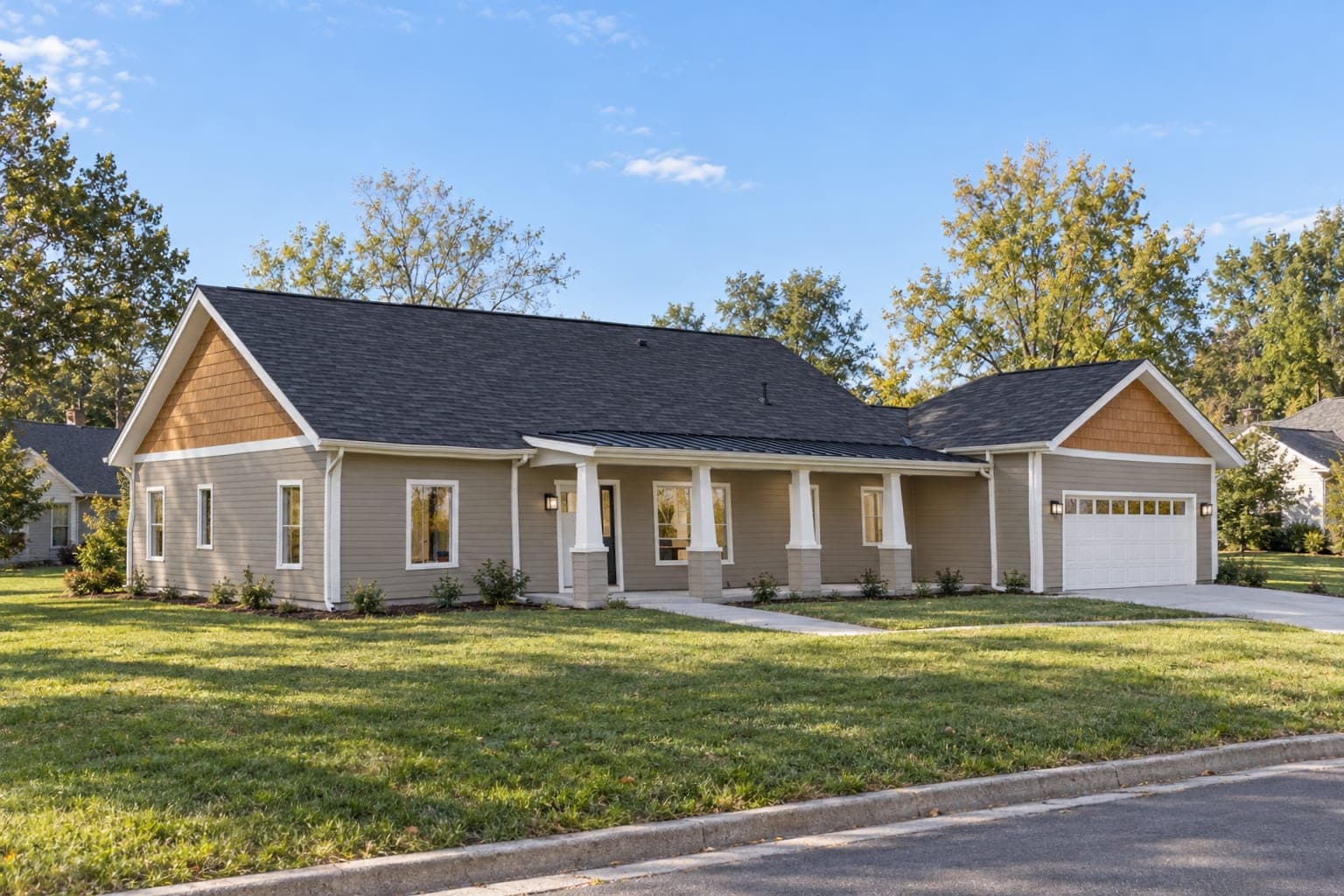 Tan Craftsman ranch from the front corner, showing the shake gables and covered front porch